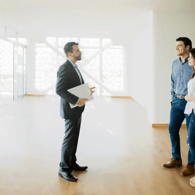 Un couple discute avec un agent immobilier dans un appartement vide
