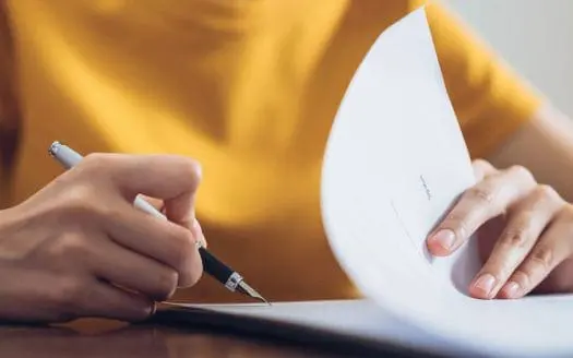 Une personne qui signe un acte de vente avant d'acheter un nouveau bien