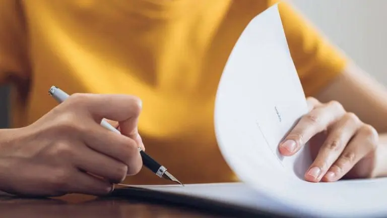 Une personne qui signe un acte de vente avant d'acheter un nouveau bien
