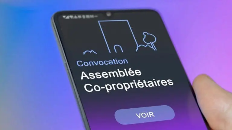 Smartphone avec la notification de convocation de l'assemblée des copropriétaires à l'écran.