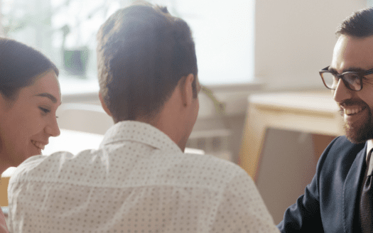Trois personnes discutent autour d'un bureau
